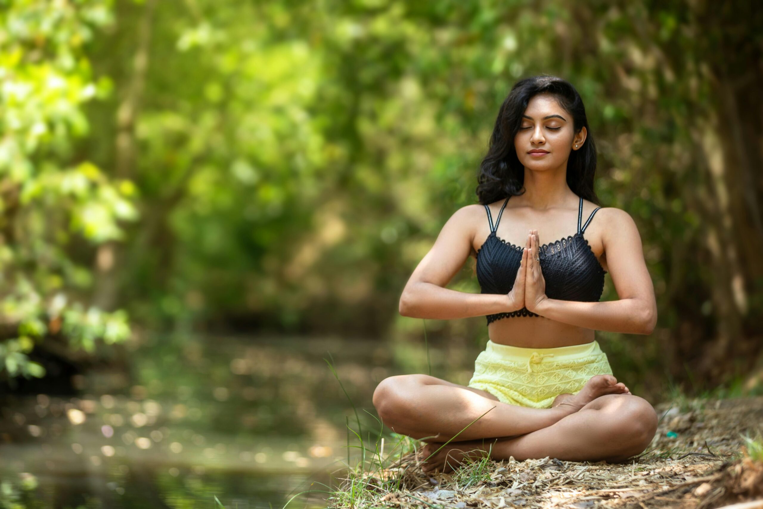 An image of a woman meditating in yoga position representing a blog post on balancing work and life for remote professionals