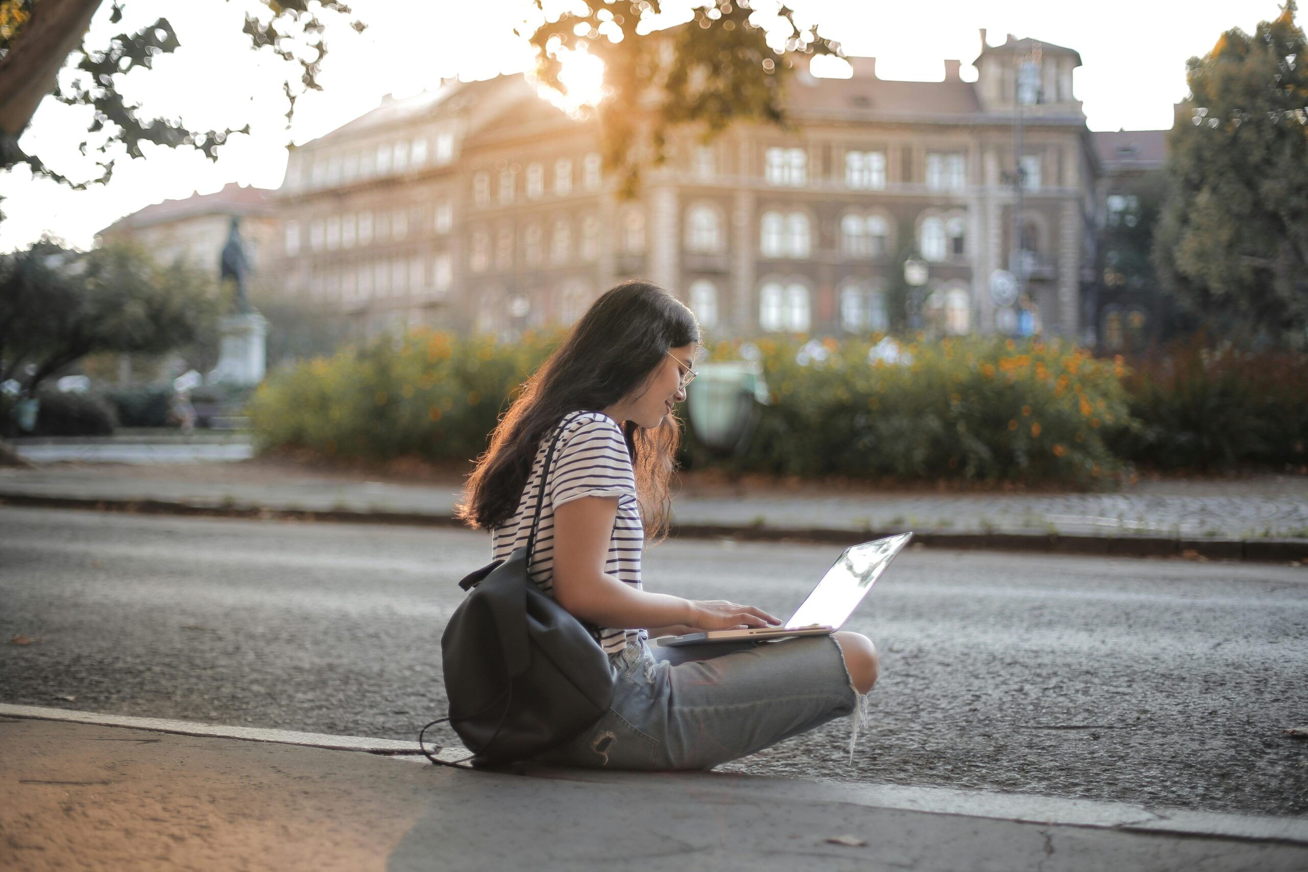 An image of a girl traveling and working on a laptop representing a blog post on tips for traveling and working remotely